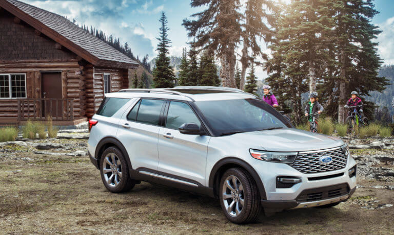 2023 Ford Explorer near a family cabin parked by a treeline inside a forest