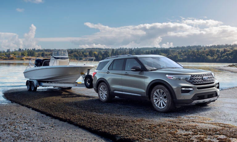 2023 Ford Explorer towing a large boat along a scenic view