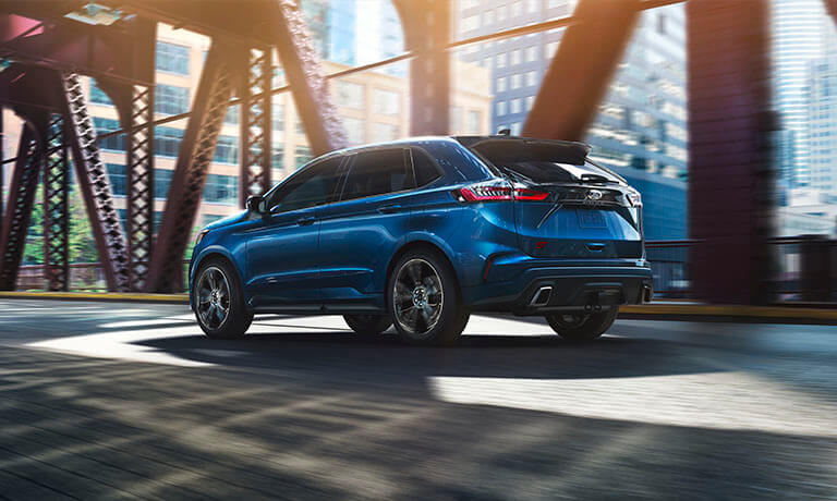 2024 Ford Edge in blue exterior driving under a bridge