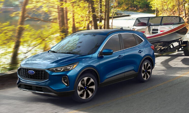 2024 Ford Escape towing a boat in a forest